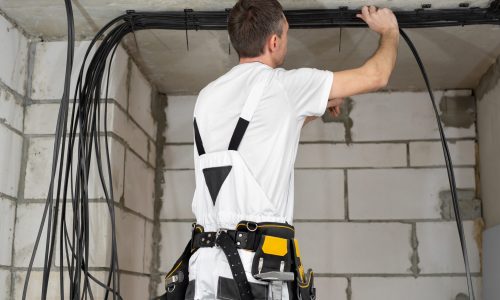 A professional electrician who installs electrical wires during apartment renovation