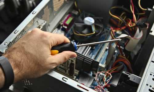 A technician repairing a desktop computer. This image has selective focus.