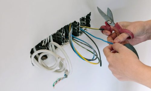 Unrecognizable female electrician working on the electrical installation of a house
